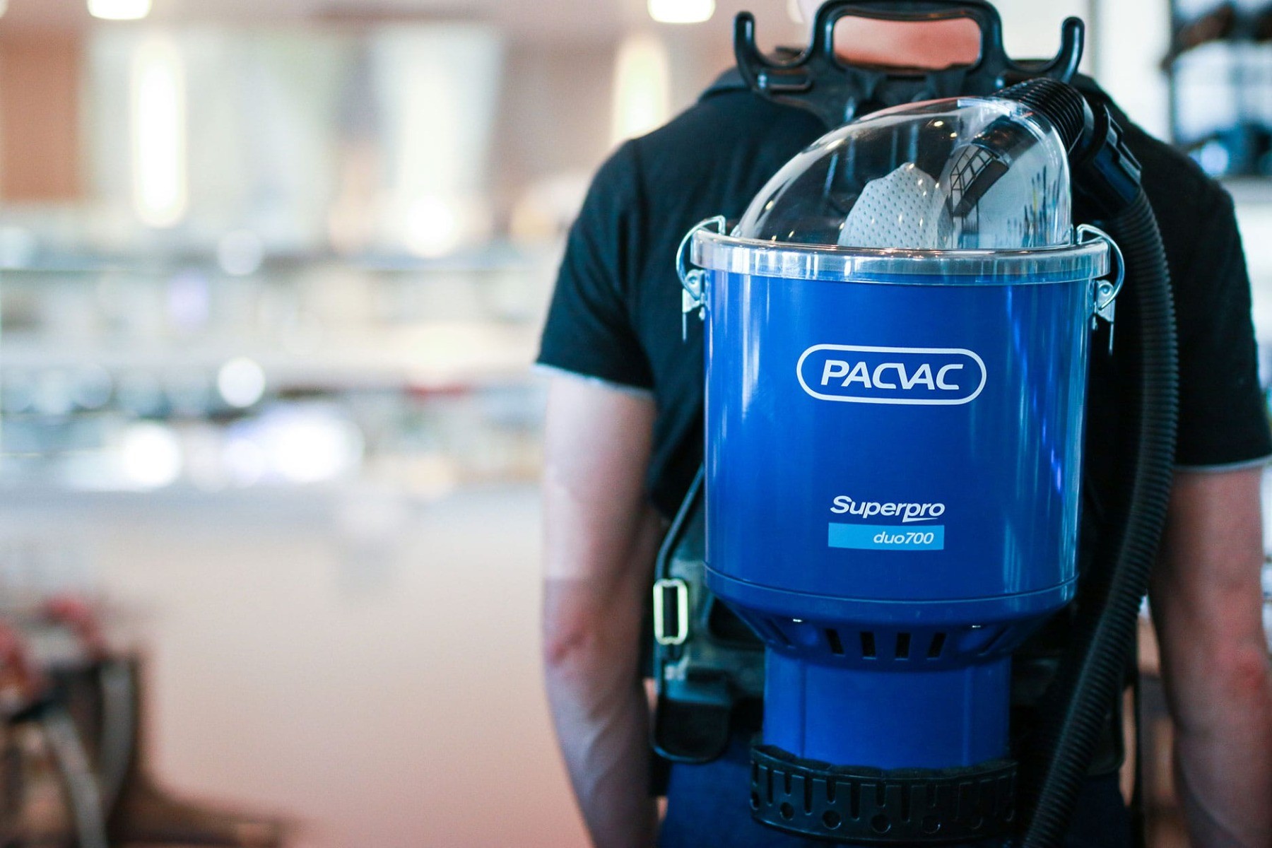 Close-up shot of a person wearing a Superpro duo 700 backpack vacuum.